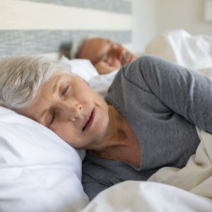 Man en vrouw liggen te slapen in hooglaagbed van Boonstra bedden