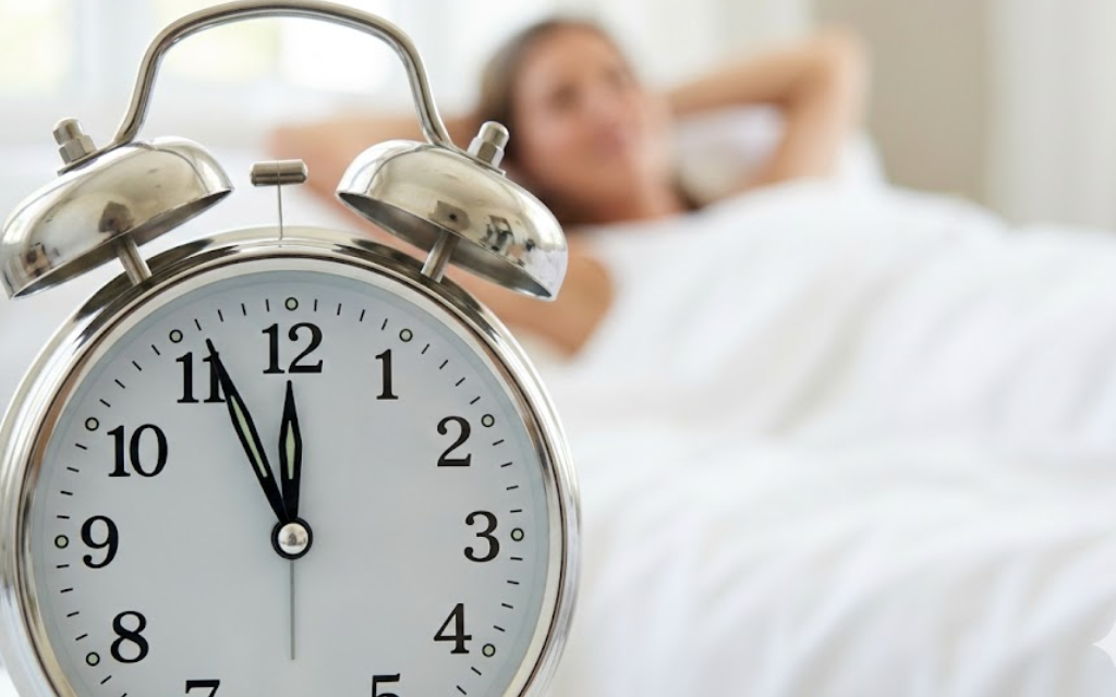 Foto van een wekker met een persoon op de achtergrond