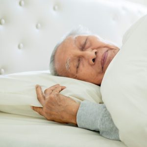 Man ligt te slapen in hooglaagbed