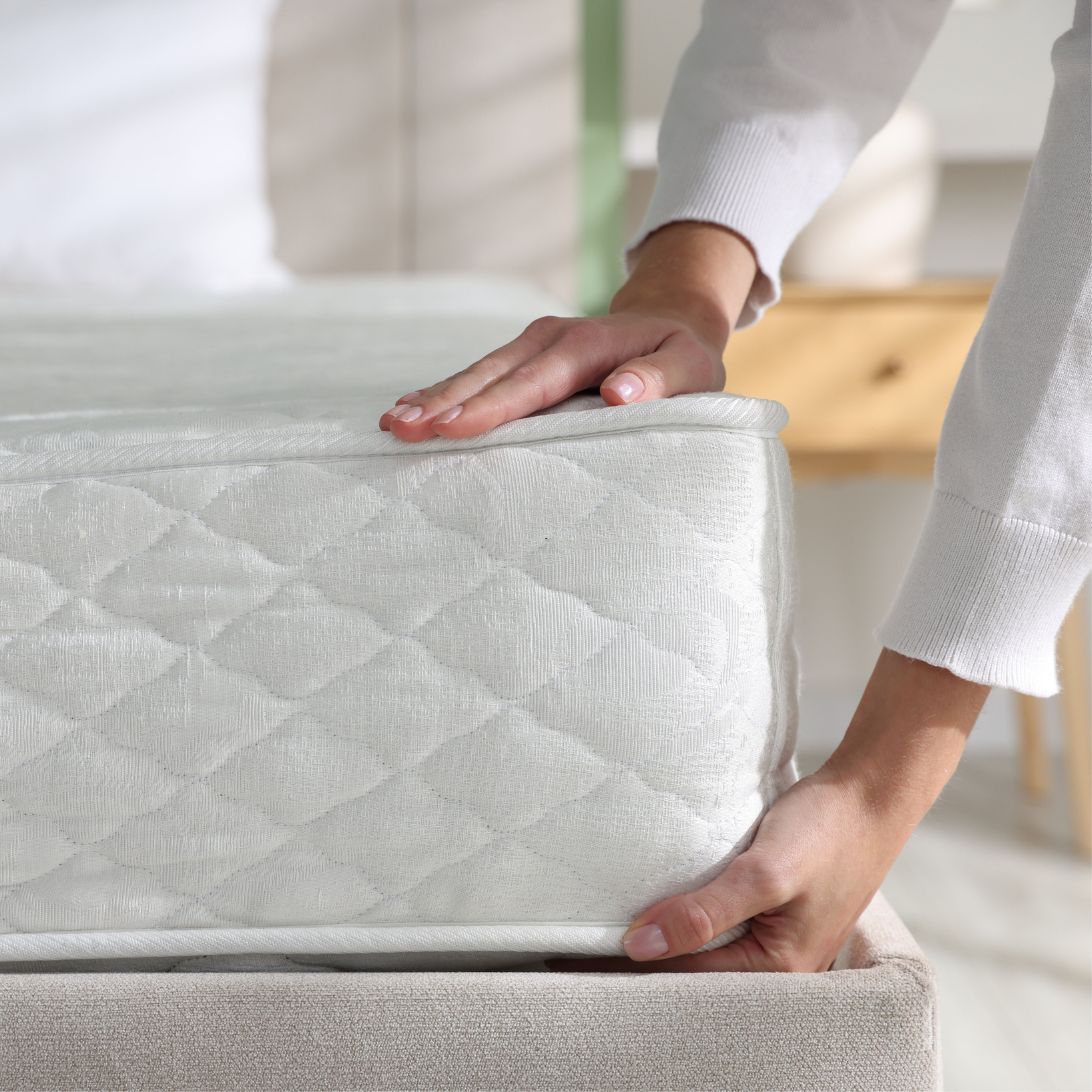 Vrouw checkt matras op kuilen in verband met aflopende levensduur matras