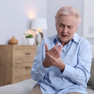 Vrouw met reuma zit op matras