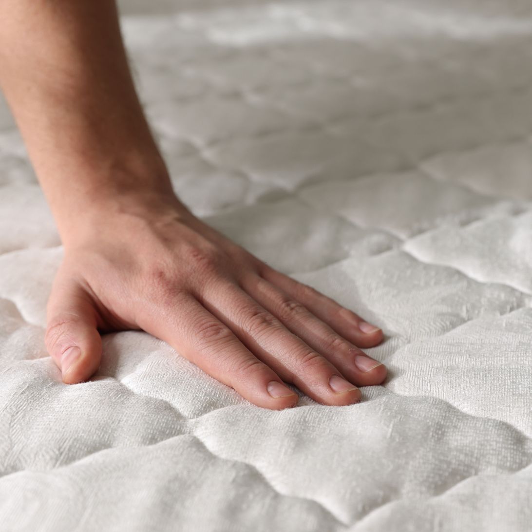 Hand checkt matras voor matrasproblemen
