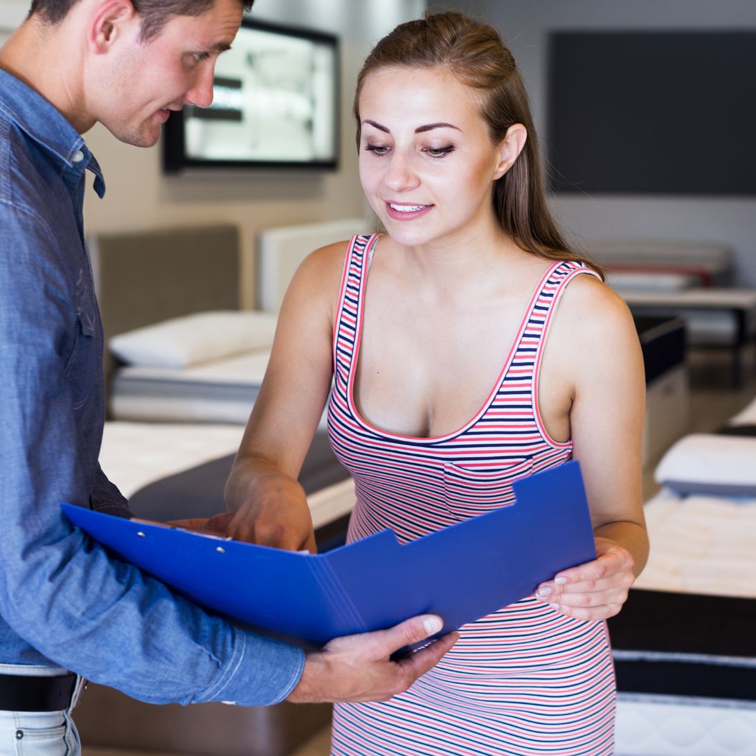 Vrouw checkt milieubijdrage nieuw matras bij verkoper