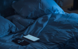 Afbeelding van een telefoon en oplader op bed