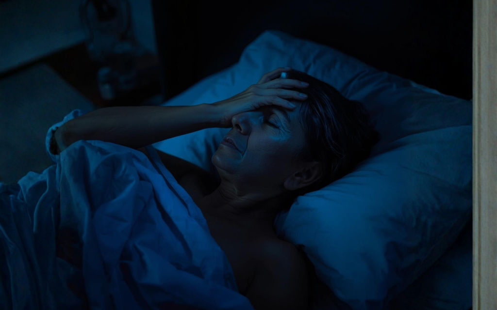 Vrouw ligt in bed en kan niet slapen door de overgang