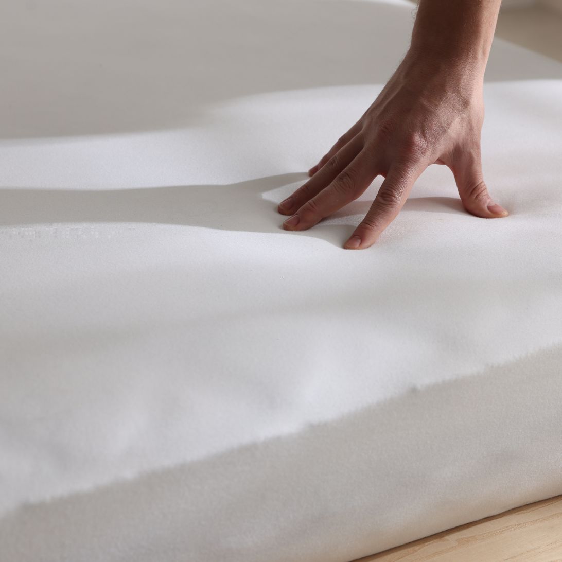 Hand drukt matras in om te checken of het een hard of zacht matras is