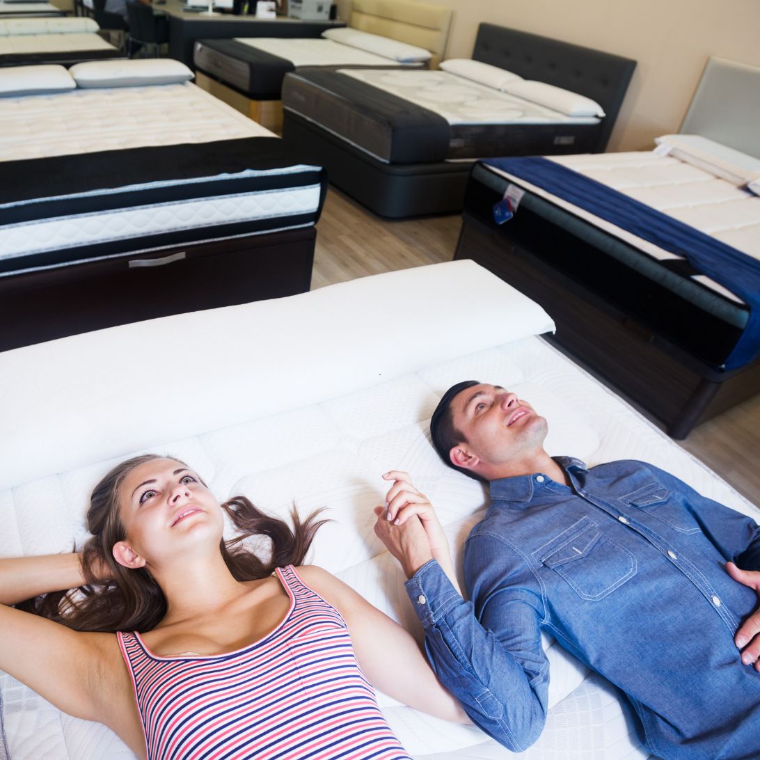 Man en vrouw testen matras voor lange mensen in winkel