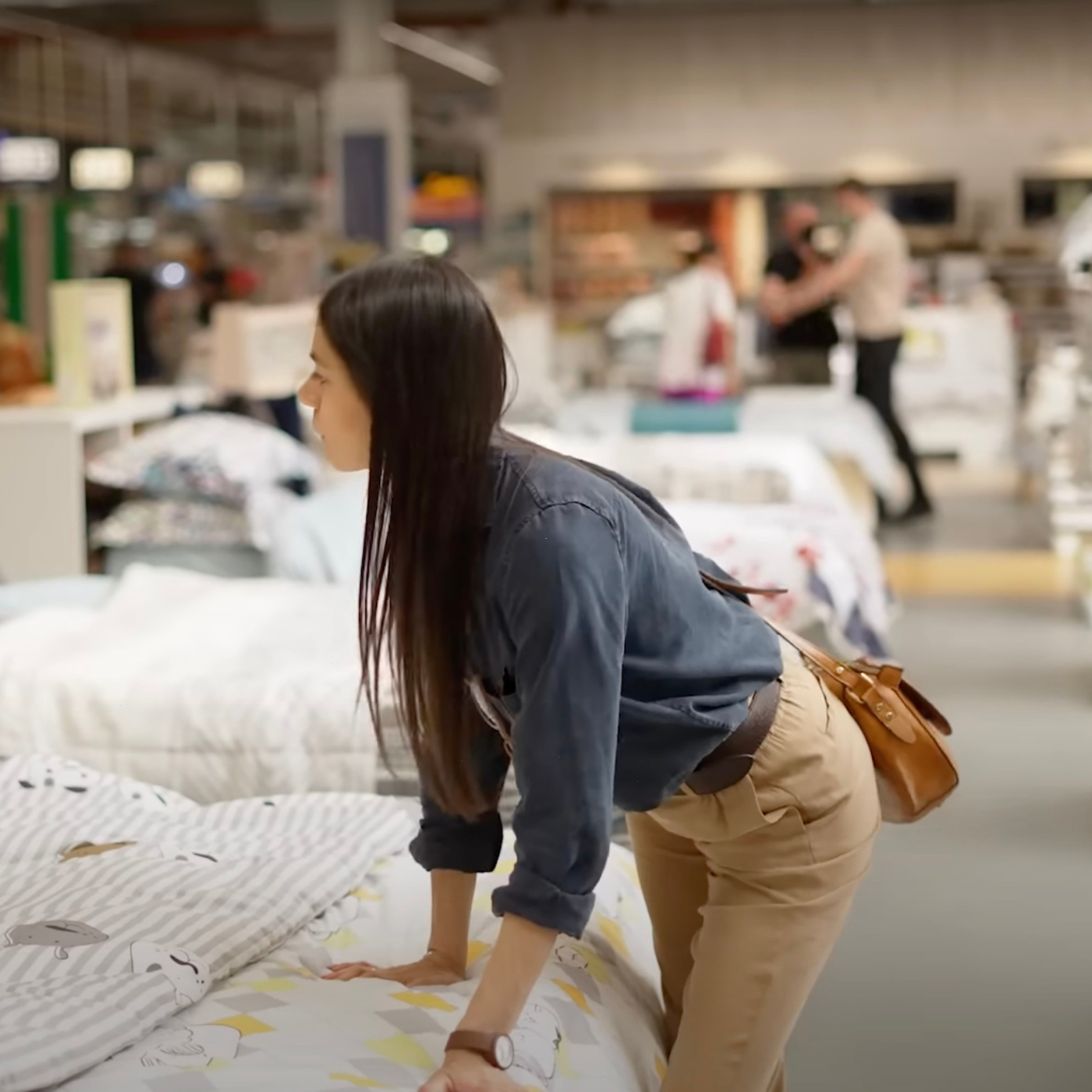 Vrouw voert matrassentesten uit in winkel
