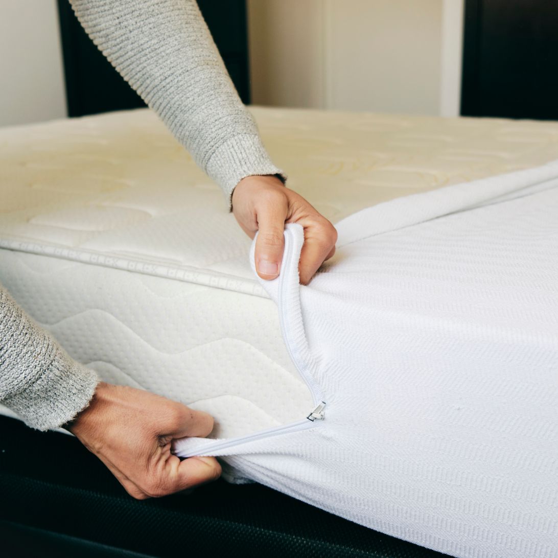 Persoon trekt matrastijk over matras