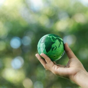 Hand houdt groene wereldbol vast
