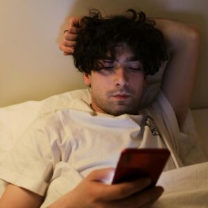 Man ervaart nekklachten door gebruik telefoon in bed
