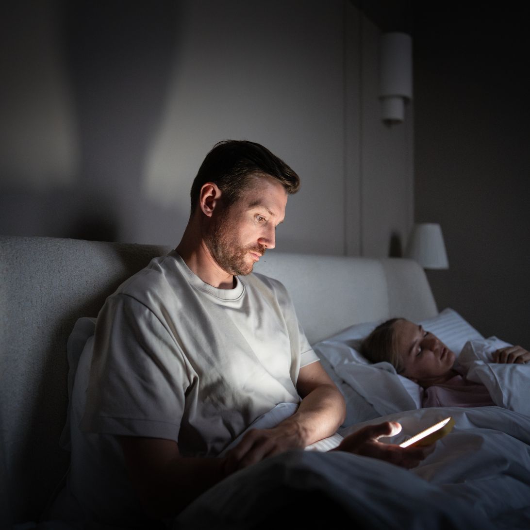 Man ervaart nekklachten door gebruik telefoon in bed