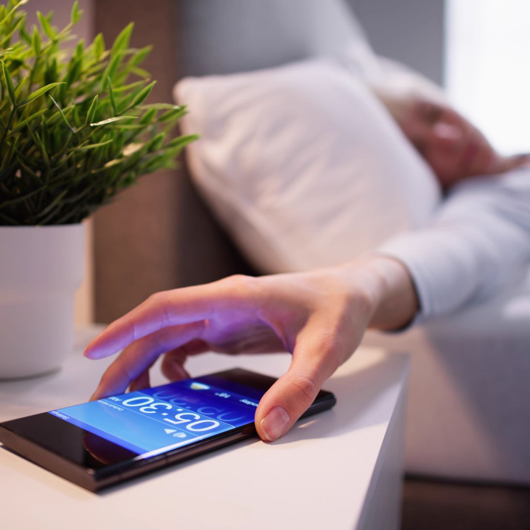 Vrouw is haar alarm aan het snoozen