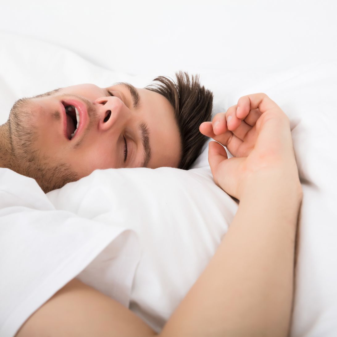 Man ligt in bed te snurken