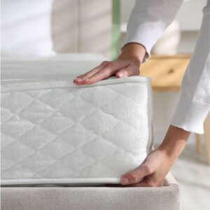 Persoon legt matras op bedbodem