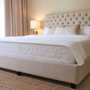 Opgemaakte boxspring in verlichte slaapkamer