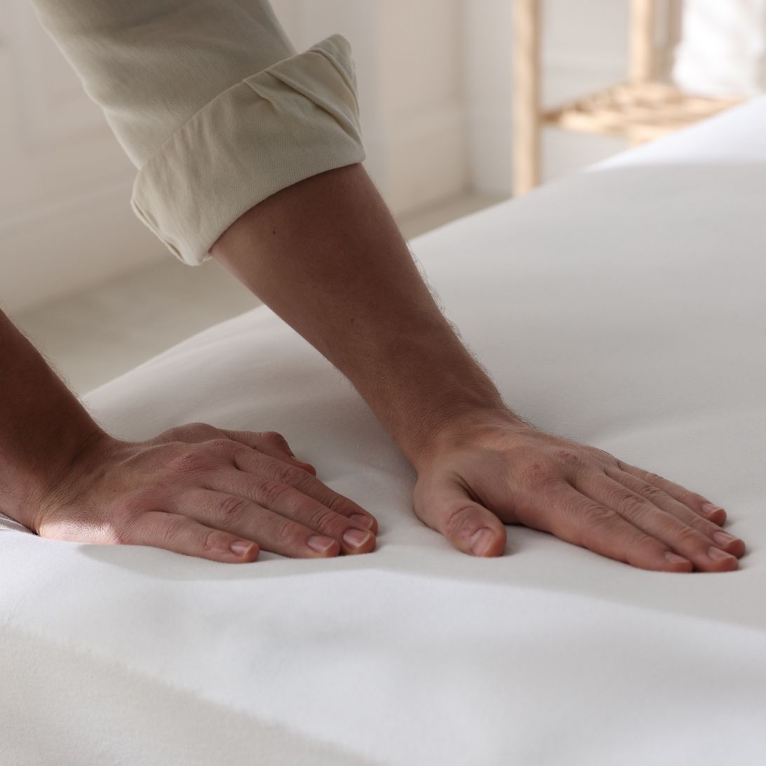 Handen van vrouw drukken stro-matras in